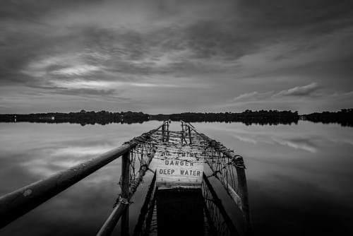 dock on lake with danger deep water sign