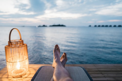 Person sitting on dock looking out over body of water